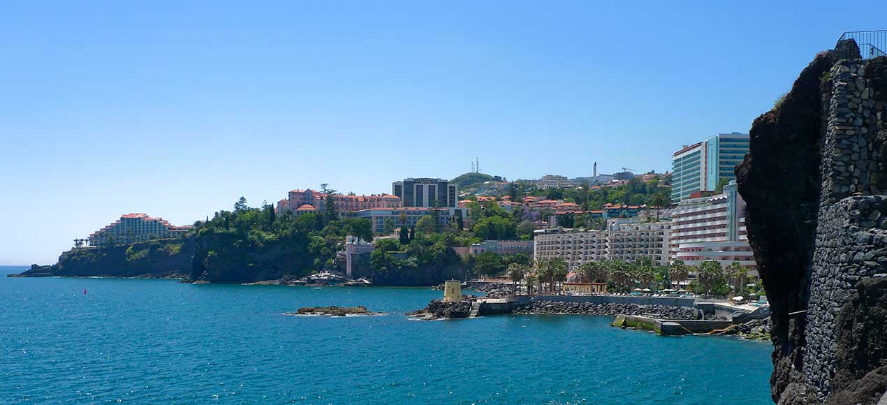 Funchal havneudsigt af hoteller fra venstre: Cliff Bay, Belmond Reid Palace, Pestana Carlton & Beach Club, Royal Savoy, Regency Club og Penha de França Mar.